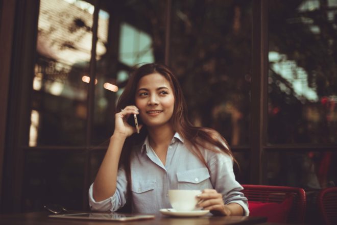 Portrait of young woman using mobile phone in cafe 323503