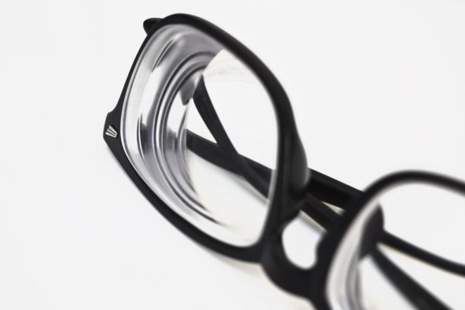 black frame eye glasses sitting on white table