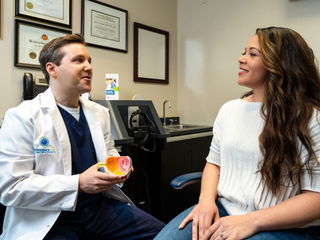 Providence Eye's Surgeon, Dr. Nunnery, speaks to a female patient about vision correction.