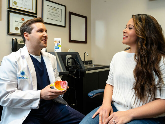 Providence Eye's Surgeon, Dr. Nunnery, speaks to a female patient about vision correction.